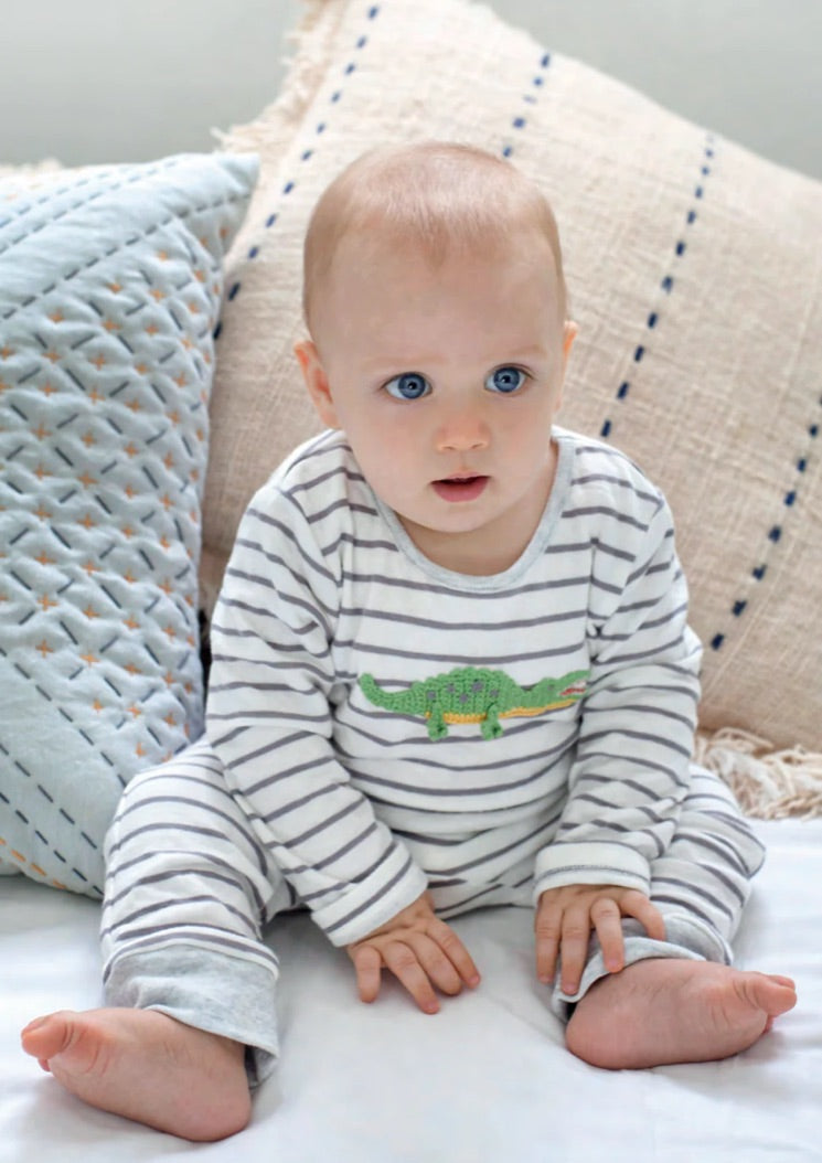 Baby boy sitting in a striped gray and white outfit for Trés Seven baby boy boutique collection