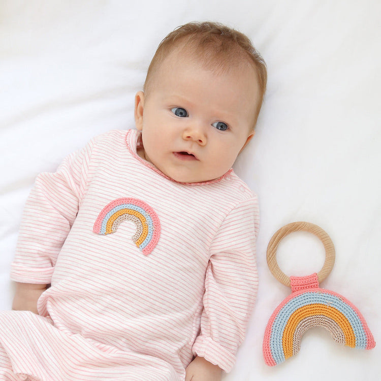 Baby girl in pink outfit with rainbow toy for Trés Seven baby girl boutique collection
