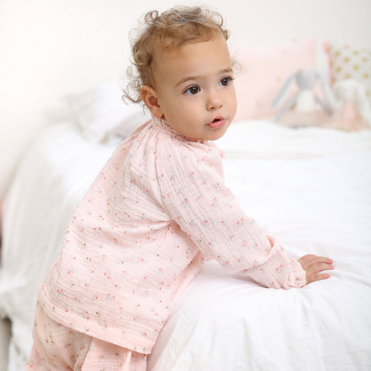 Baby girl wearing soft pink outfit for Trés Seven baby girl clothing collection